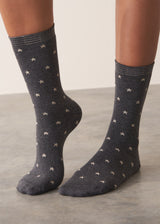 Person wearing grey cotton blend socks with metallic silver star accents and sparkle detail on the ankle, standing on a grey surface