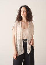 Woman wearing light beige cardigan with black trousers