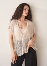 Woman wearing light beige cardigan with black trousers