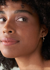 Woman wearing contemporary gold hoop earrings with crystal detail