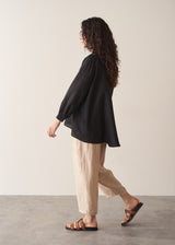 Woman wearing a black longline shirt with oatmeal linen trousers