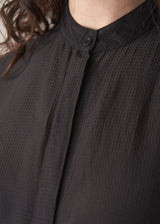 Woman wearing a black longline shirt with oatmeal linen trousers