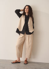Woman wearing a black longline shirt with oatmeal linen trousers