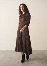 Woman wearing dark brown leopard print satin dress