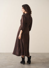 Woman wearing dark brown leopard print satin dress