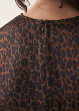 Woman wearing dark brown leopard print satin dress