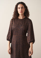 Woman wearing dark brown leopard print satin dress