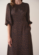 Leopard print dress worn by a person on a plain background