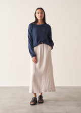 Woman wearing grey tank top and neutral linen midi skirt