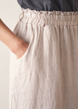Woman wearing grey tank top and neutral linen midi skirt