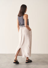 Woman wearing grey tank top and neutral linen midi skirt