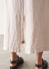 Woman wearing grey tank top and neutral linen midi skirt