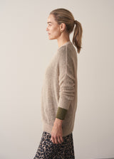 Woman wearing neutral sheer cardigan with. mother of pearl buttons and leopard print barrel leg trousers