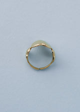 Side view of a gold hammered heart ring on blue background