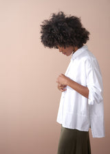 Woman wears a white boxy oversized cotton shirt with satin skirt