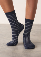 Person wearing midnight blue Neve Socks with a metallic silver stripe and a scalloped ankle detail