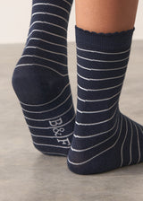 Person wearing midnight blue Neve Socks with a metallic silver stripe and a scalloped ankle detail