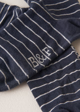 Close up of "B&F" branding on midnight blue Neve Socks with a metallic silver stripe and a scalloped ankle detail