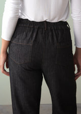 Dark denim cotton jeans worn by a person against a neutral background