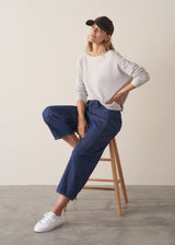 Woman wearing grey relaxed sweater with blue barrel leg jeans