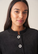 Woman wearing plush herringbone cropped jacket iwth matching trousers and a white top