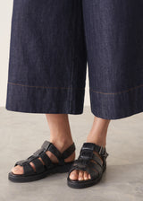 Woman wearing a white top and dark navy wide-leg denim cullottes