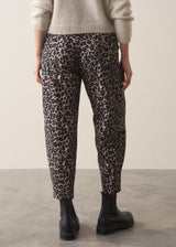 Woman wearing oatmeal mohair jumper and leopard print barrel leg jeans with black boots