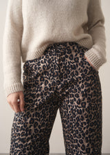 Woman wearing oatmeal mohair jumper and leopard print barrel leg jeans