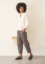 Woman wearing leopard print trousers and a white shirt
