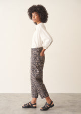 Woman wearing leopard print trousers and a white shirt