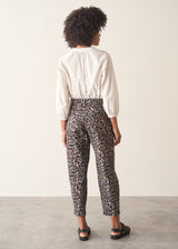 Woman wearing leopard print trousers and a white shirt