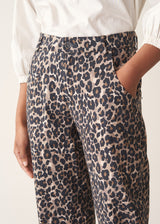 Woman wearing leopard print trousers and a white shirt
