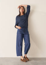 Woman wearing navy blue sweatshirt with drawstring and blue jeans