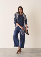 Woman wearing navy blue sweatshirt with drawstring and blue jeans
