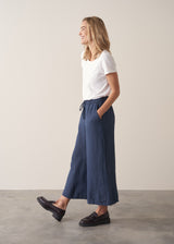 Woman wearing navy blue wide leg linen trousers with matching linen shirt
