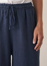 Woman wearing navy blue wide leg linen trousers with matching linen shirt
