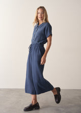 Woman wearing navy blue wide leg linen trousers with matching linen shirt