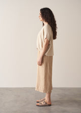 Woman wearing oatmeal sleeveless knitted top with wide leg linen trousers in oatmeal beige