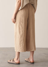 Woman wearing oatmeal sleeveless knitted top with wide leg linen trousers in oatmeal beige