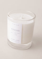 Close up of powder scented candle with notes of black pepper and lemon, on a beige background