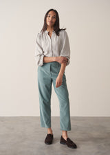 Woman wearing corduroy tapered trousers in aqua and pale checked shirt