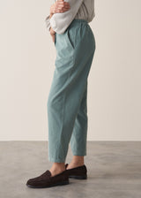 Woman wearing corduroy tapered trousers in aqua and pale checked shirt