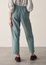 Woman wearing corduroy tapered trousers in aqua and pale checked shirt