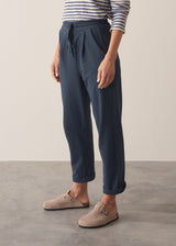 Woman wearing dark blue-grey cotton joggers and navy and cream stripe top