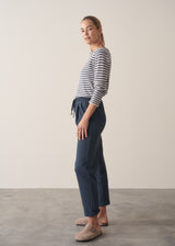 Woman wearing dark blue-grey cotton joggers and navy and cream stripe top