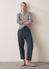 Woman wearing dark blue-grey barrel leg cotton joggers and navy and cream stripe top