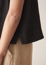 Woman wearing black linen boxy top with oatmeal linen trousers