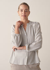 Woman wearing light blue and white check blouse