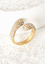 Chunky gold crystal adorned loop ring on concrete background