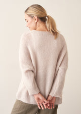 Woman wearing off white soft sweater and light khaki trousers